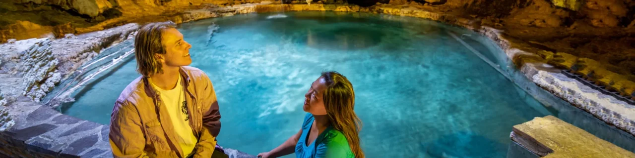 A couple laughing next to the Cave and Basin