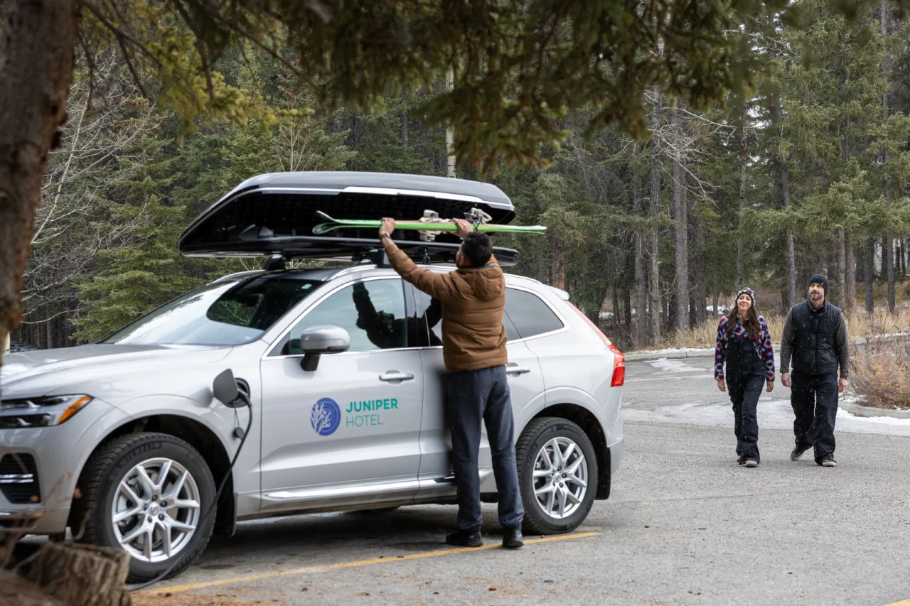 A Juniper Hotel staff member loads skis into the Juniper Shuttle