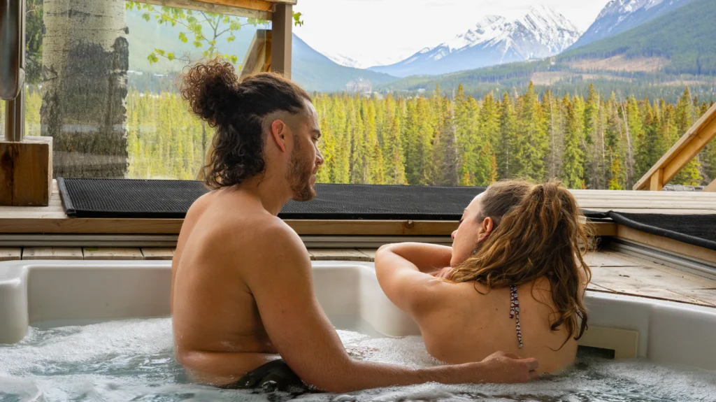 A romantic couple enjoy an intimate hot tub experience overlooking the valley