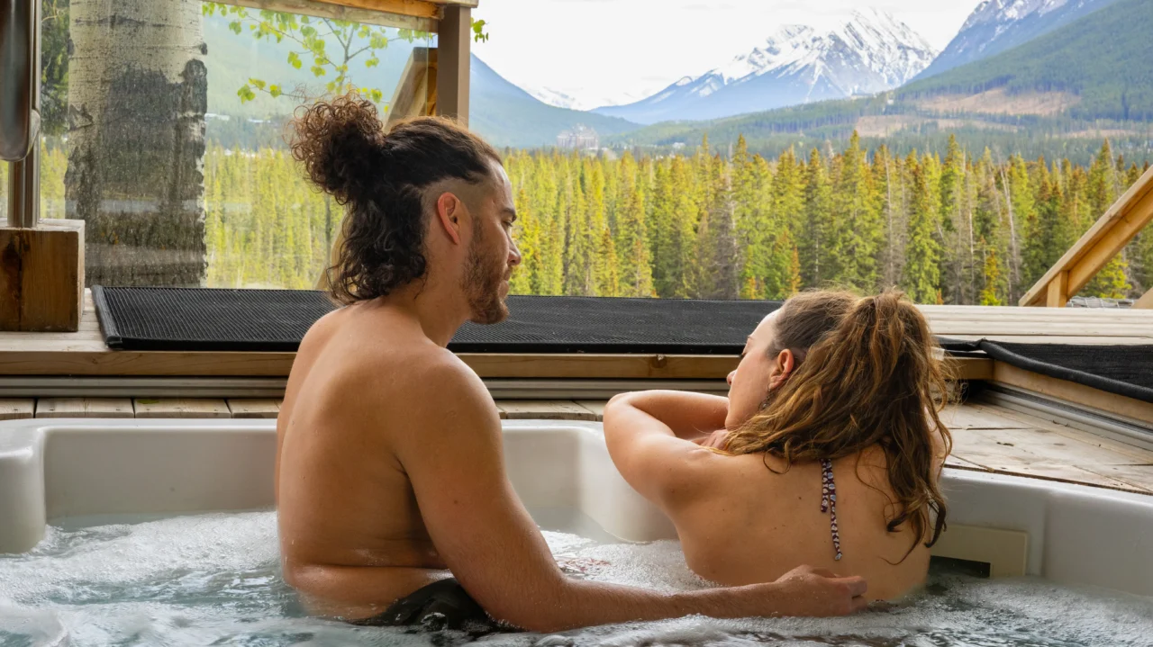 A romantic couple enjoy an intimate hot tub experience overlooking the valley