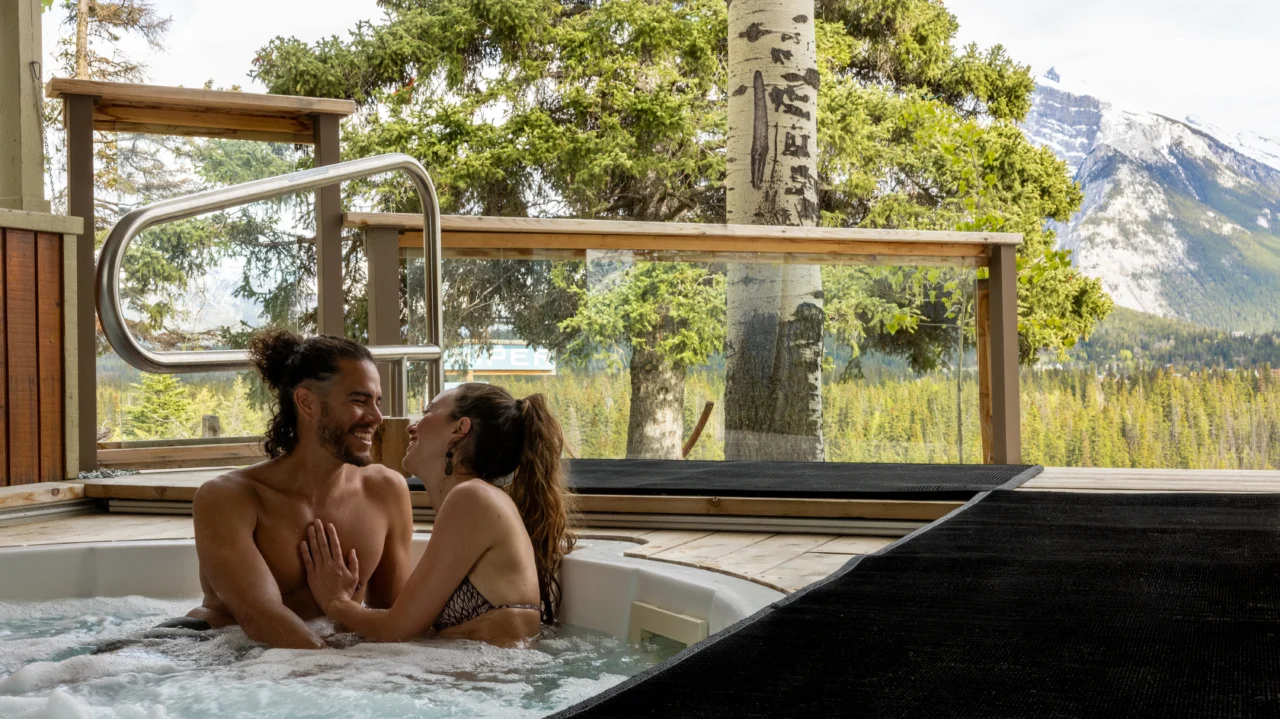 A romantic couple enjoy an intimate hot tub experience overlooking the valley