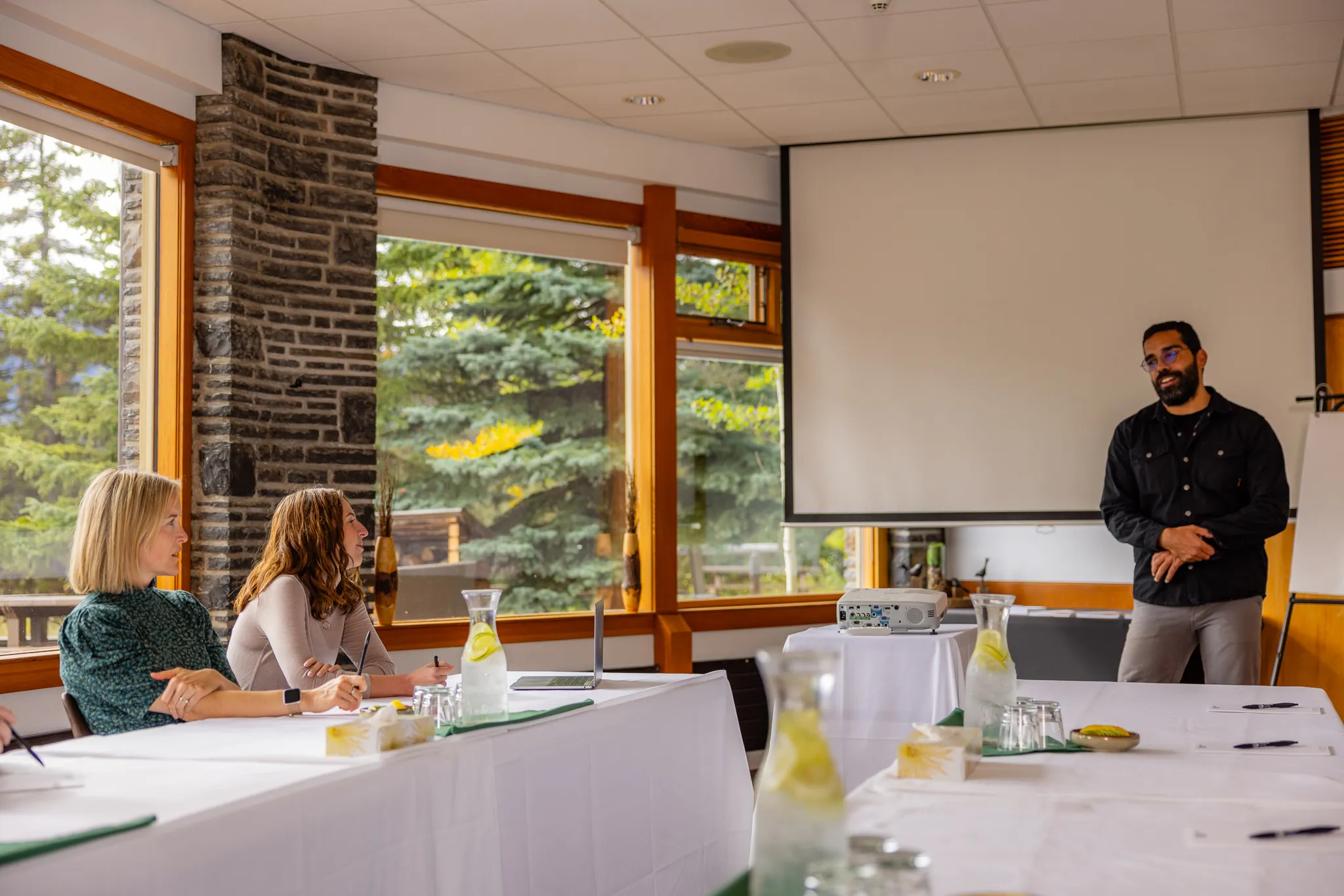 A group of business professionals have a meeting in a bright, airy room at the Juniper Hotel