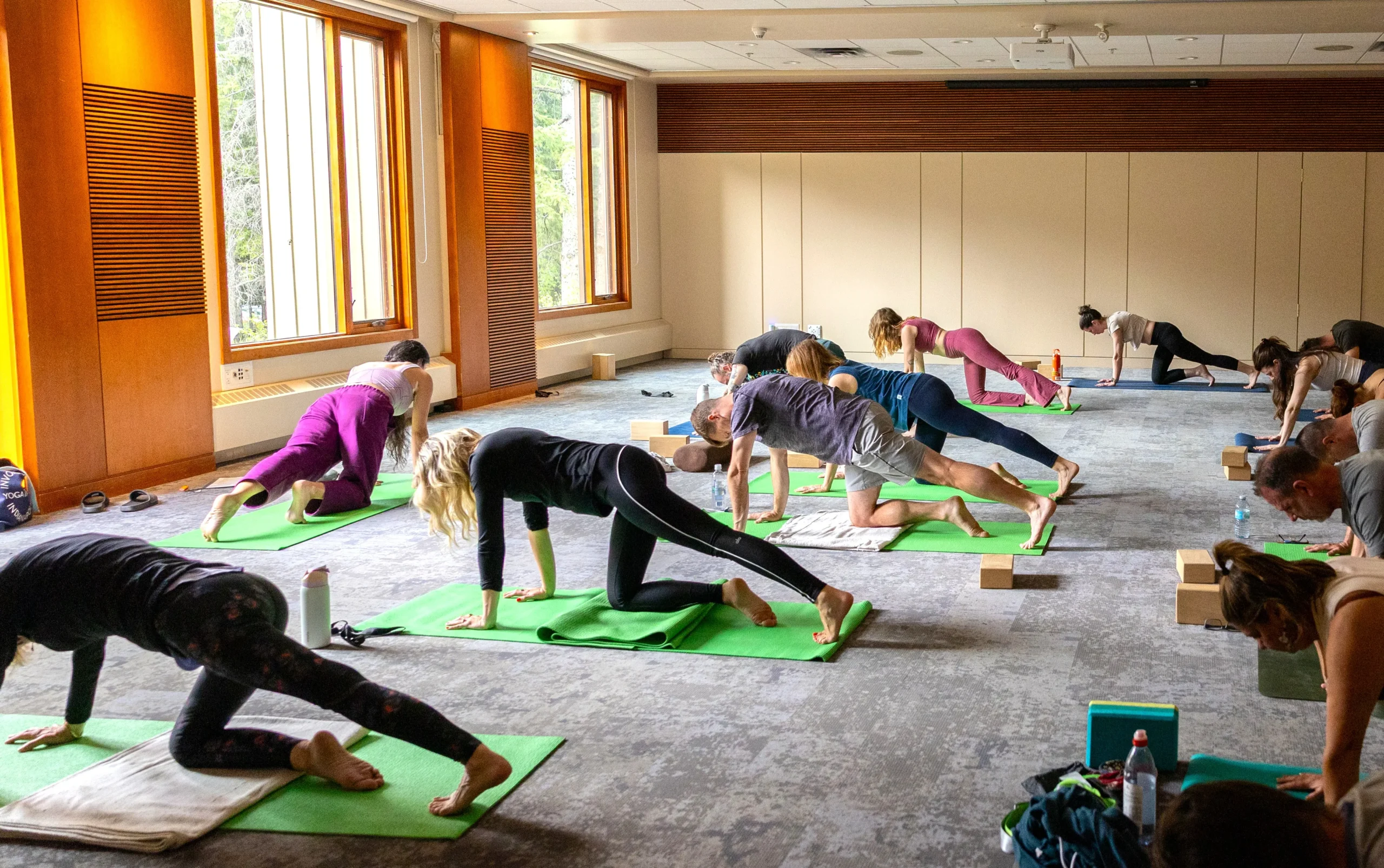 A group of wellness lovers have a yoga session in a bright, airy room at the Juniper Hotel