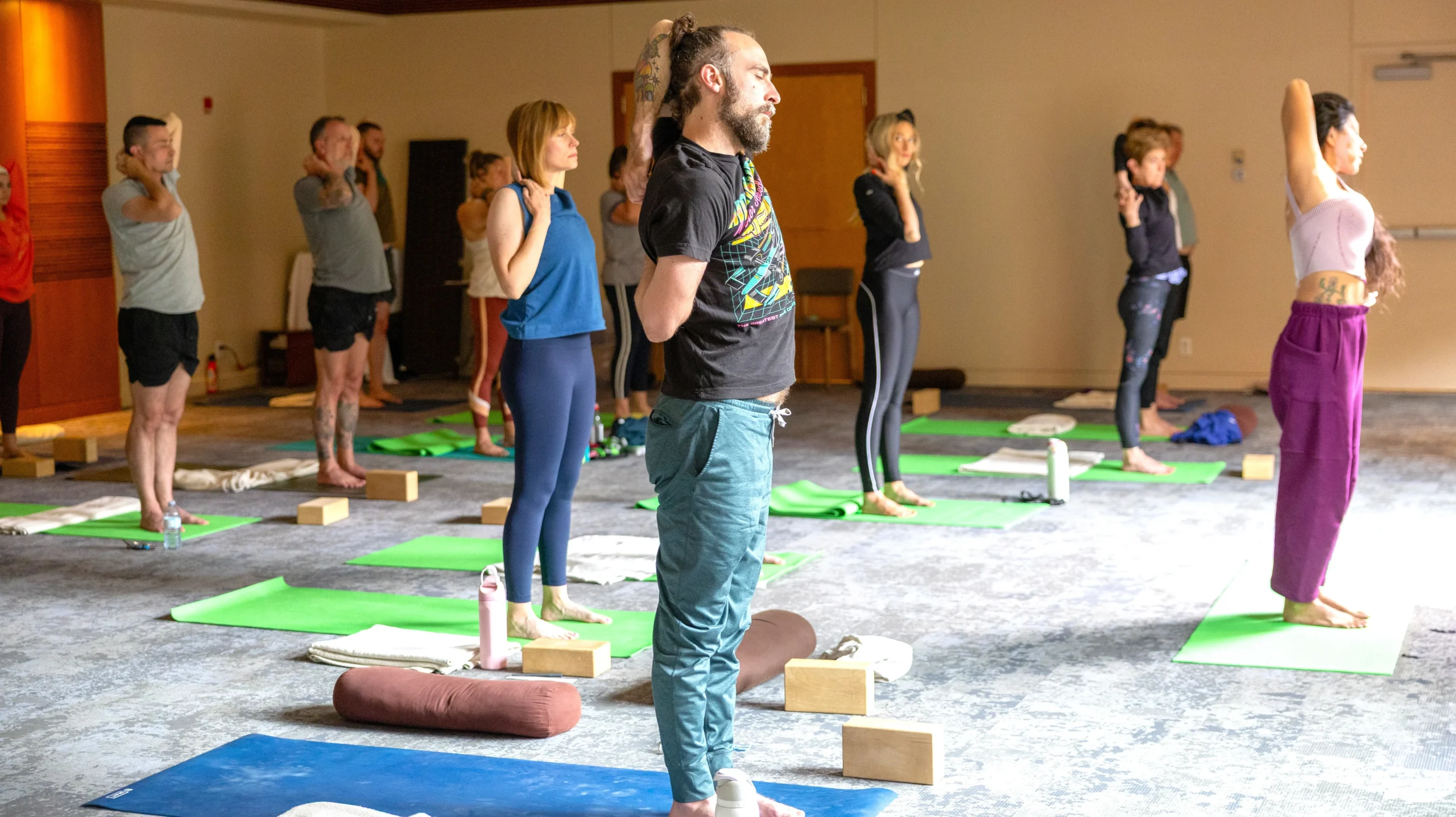 A group of wellness lovers have a yoga session in a bright, airy room at the Juniper Hotel