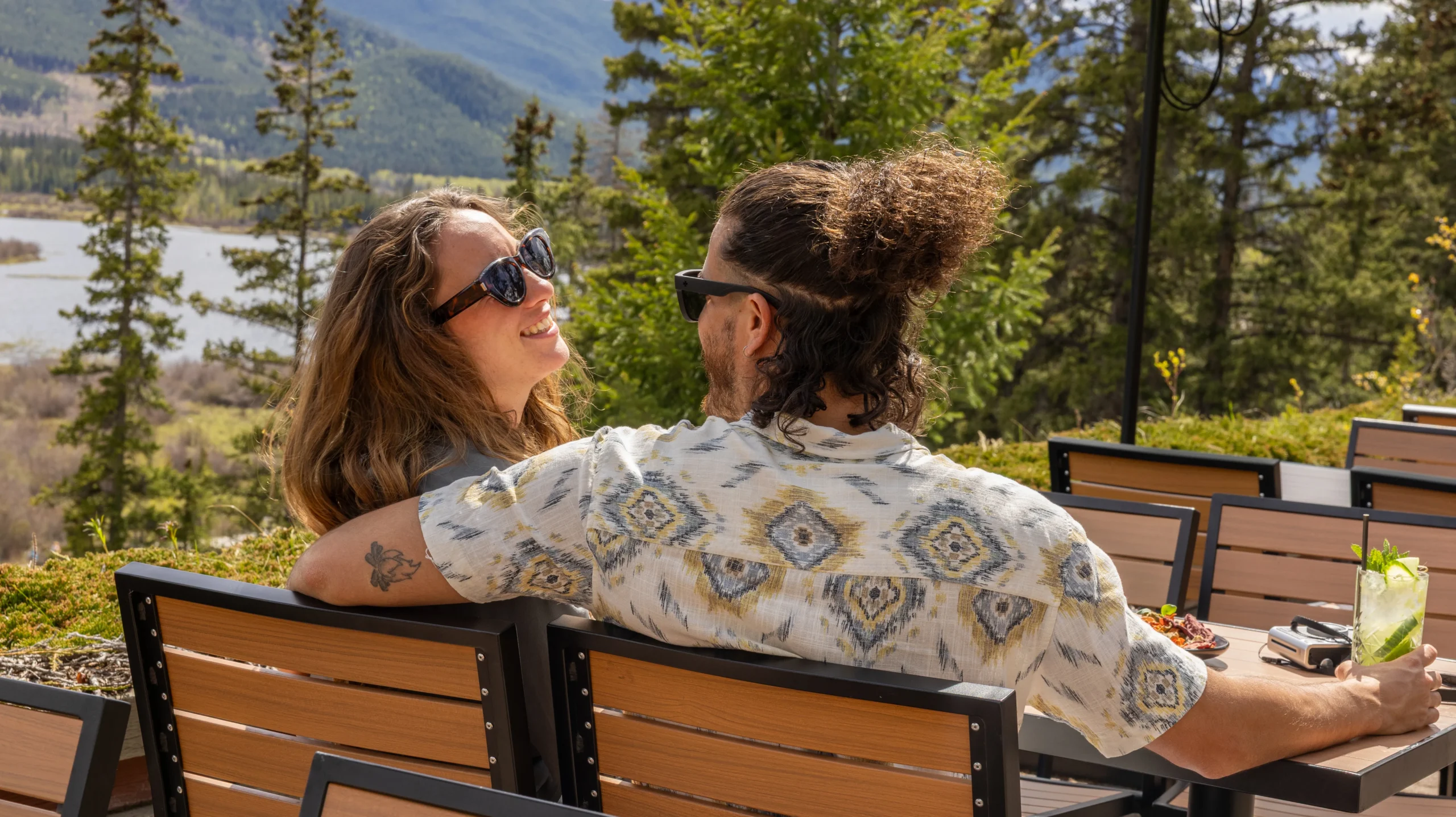 A couple enjoying cocktails and sun on the Juniper patio