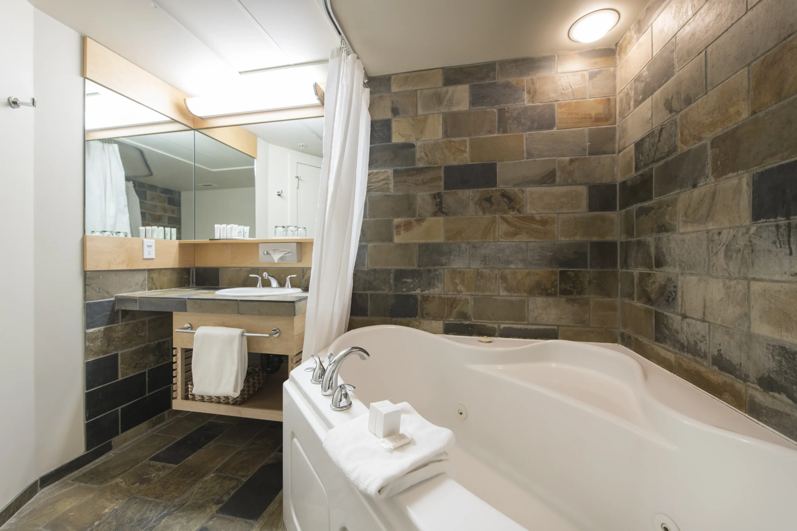 The Juniper king suite layout includes a sofa, fireplace and views over Banff from the private balcony.