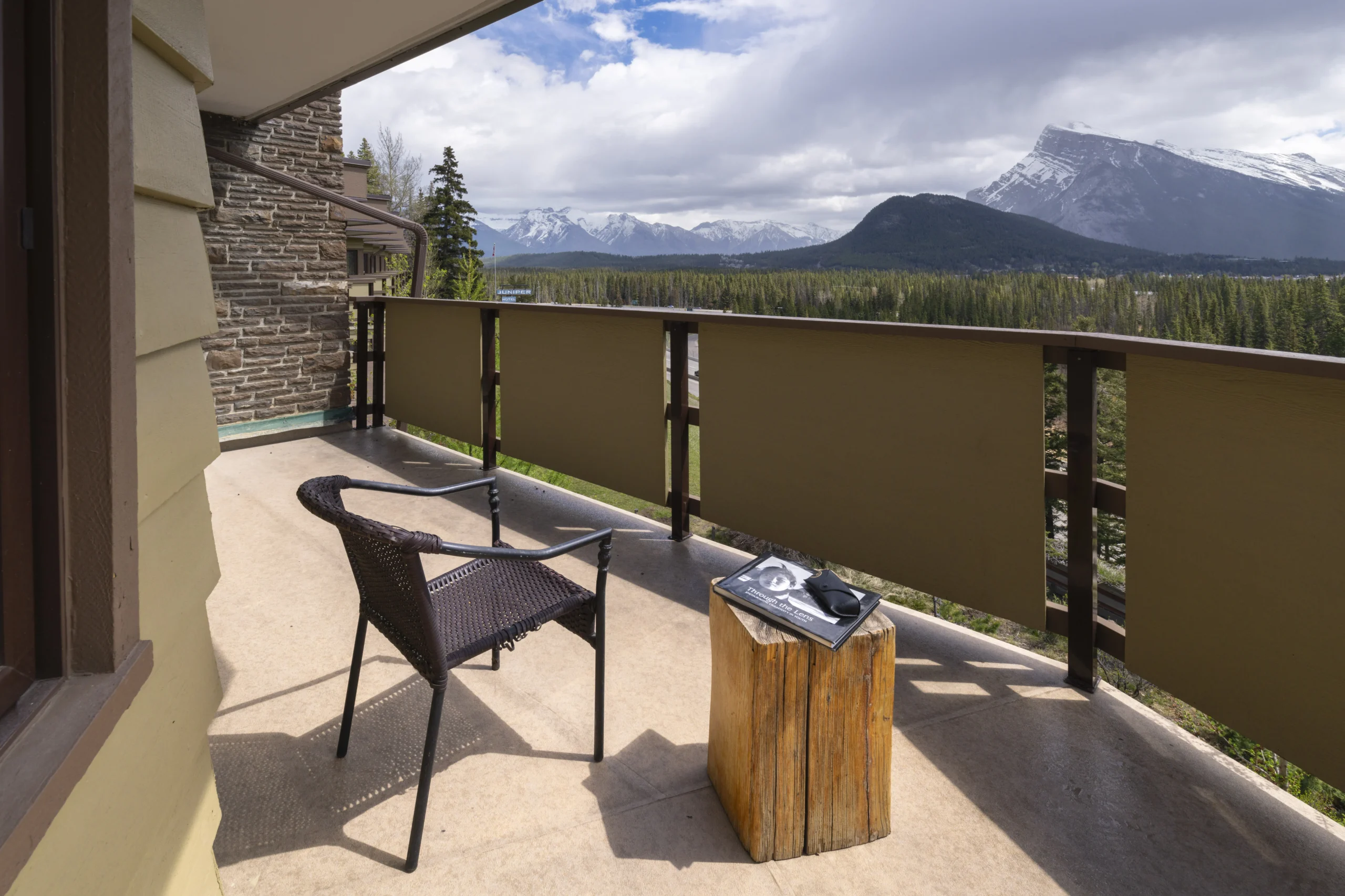 The Juniper king suite layout includes a sofa, fireplace and views over Banff from the private balcony.