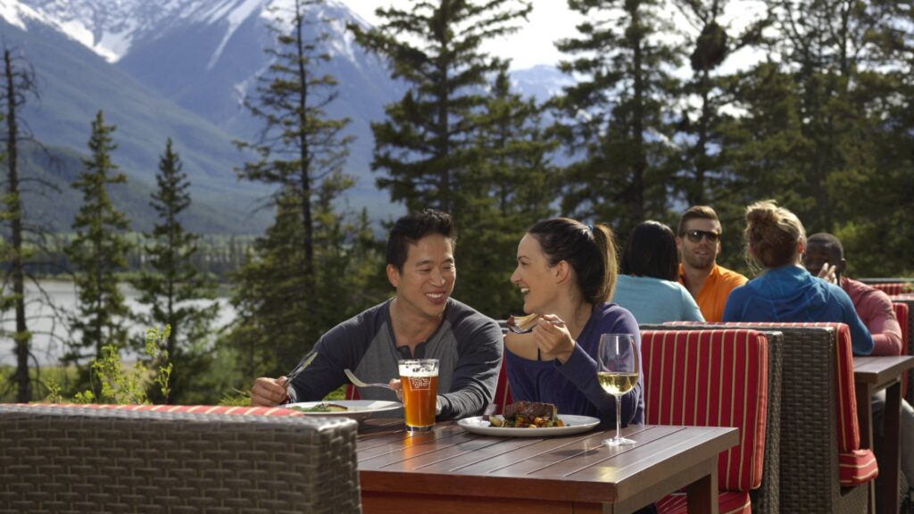 A couple enjoying their Juniper Bistro meal with Vermillion Lakes in the background