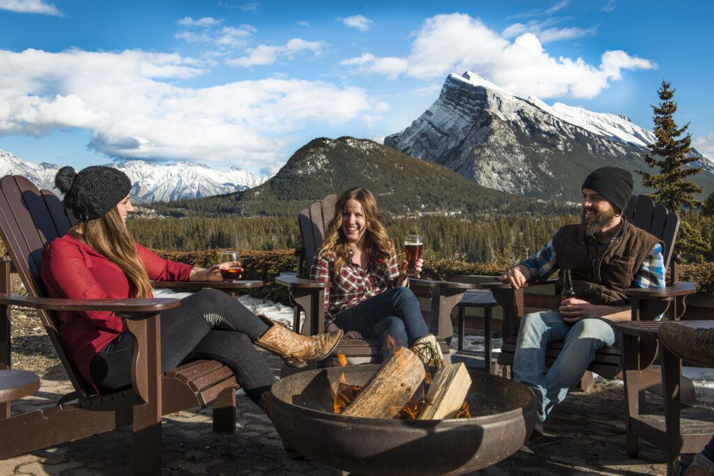 Three friends enjoy beers and wine on the Juniper Patio in late Fall
